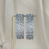 Pair of silver american diamond bangles on a gold stand against a neutral background